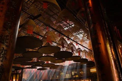 Hong Kong Temple Culture | Safari Sutra Holidays Incense coils and worshippers at a Taoist temple in Hong Kong — cultural experiences for Indian travellers