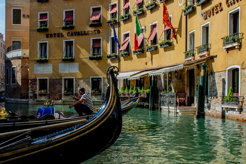 Venice Canal Culture | Safari Sutra Holidays Venice gondola on a narrow canal — cultural experience on Italy holiday packages from India | Safari Sutra Holidays