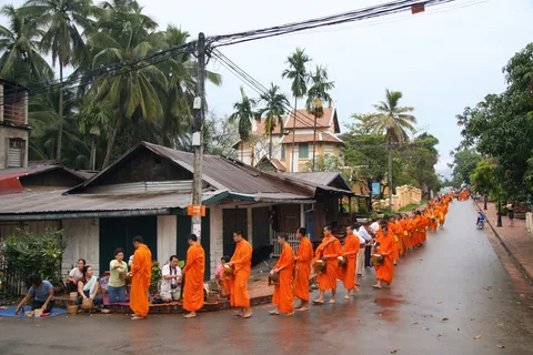 Alms Giving Ceremony Luang Prabang | Safari Sutra Holidays Buddhist monks collecting alms at dawn in Luang Prabang Laos – cultural tour packages from India