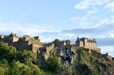 Edinburgh Castle Scotland | Safari Sutra Holidays Edinburgh Castle on volcanic rock at dusk — Scotland UK tour packages from India | Safari Sutra Holidays