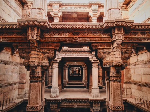 The Intricate Adalaj Stepwell near Ahmedabad A view looking down through the multiple levels of the Adalaj Stepwell, showcasing its intricately carved sandstone pillars and galleries