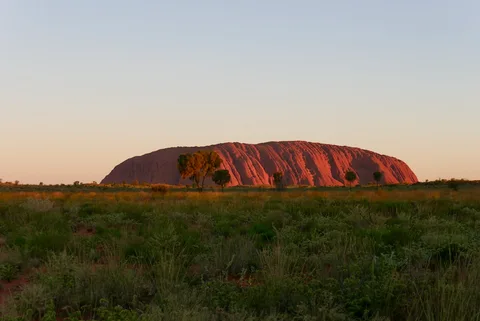 Australia Photography Grand Circuit | Safari Sutra Holidays Uluru at sunrise turning deep red, star trails above — Australia photography tour from India