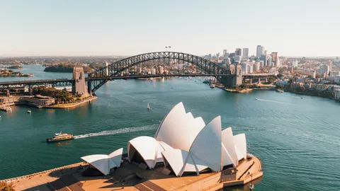 Australia Family Grand Loop: Sydney, Cairns & Melbourne | Safari Sutra Holidays Sydney Opera House and Harbour Bridge at sunrise — Australia family tour package from India