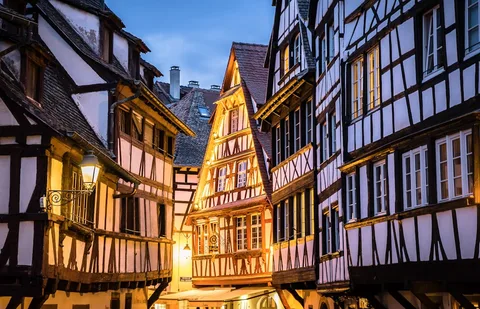 France in Lights: Alsace Christmas Markets & Winter Paris | Safari Sutra Holidays Strasbourg Christmas market with lights and half-timbered houses — France festive tour package