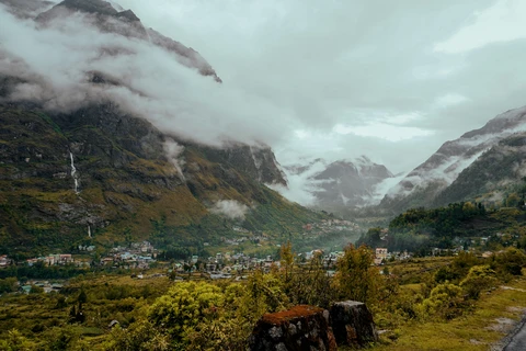 The remote village of Lachung nestled deep in a valley, surrounded by towering, cloud-shrouded Himalayan peaks in North Sikkim