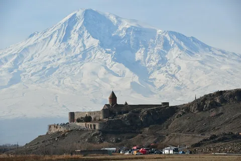 Monasteries, Mountains & Mount Ararat: Georgia & Armenia | Safari Sutra Holidays Khor Virap monastery below snow-capped Mount Ararat on a Georgia Armenia tour package from India