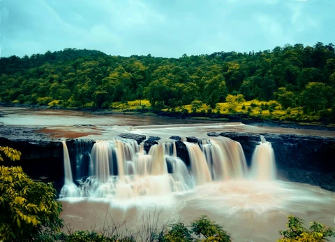 Gira Waterfalls cascading amid lush greenery