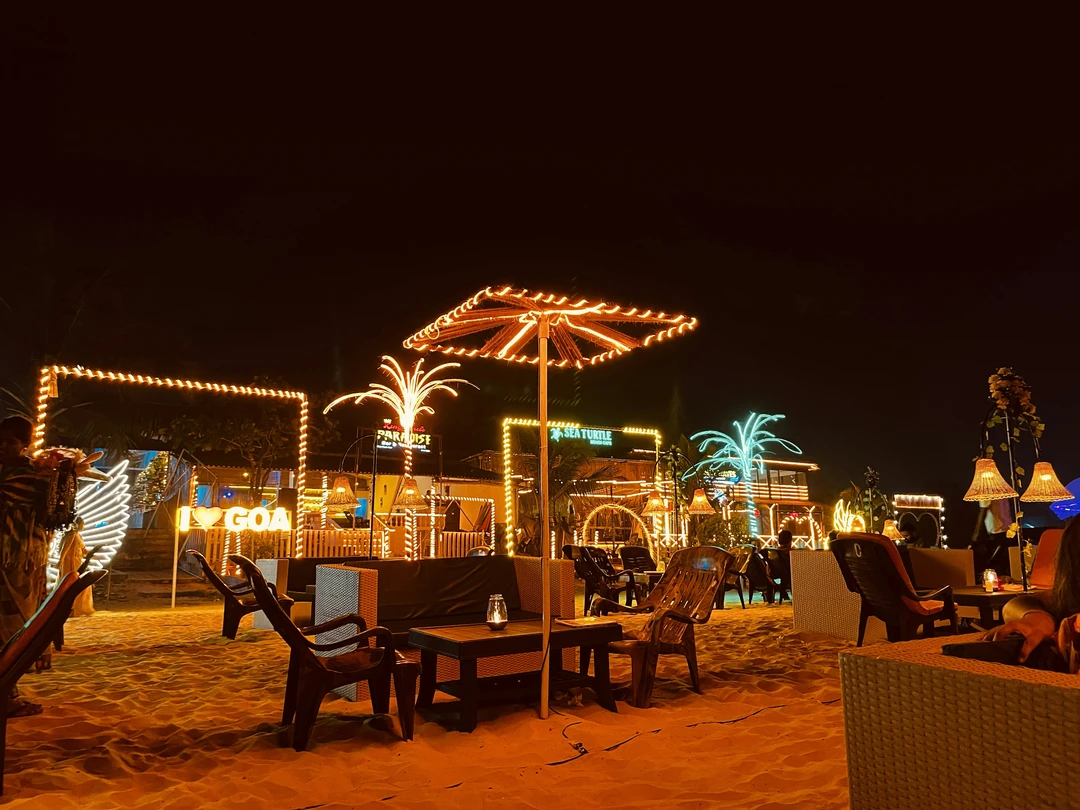 Nightlife at a Goa beach shack with glowing lights, palm decor, and sandy seating