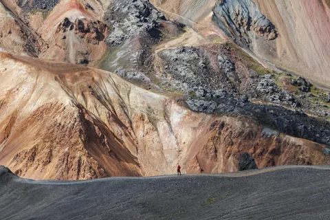 Fissures, Fire & Ice: Iceland Adventure Tour | Safari Sutra Holidays Hiker among the colourful rhyolite mountains of Landmannalaugar on an Iceland adventure tour package