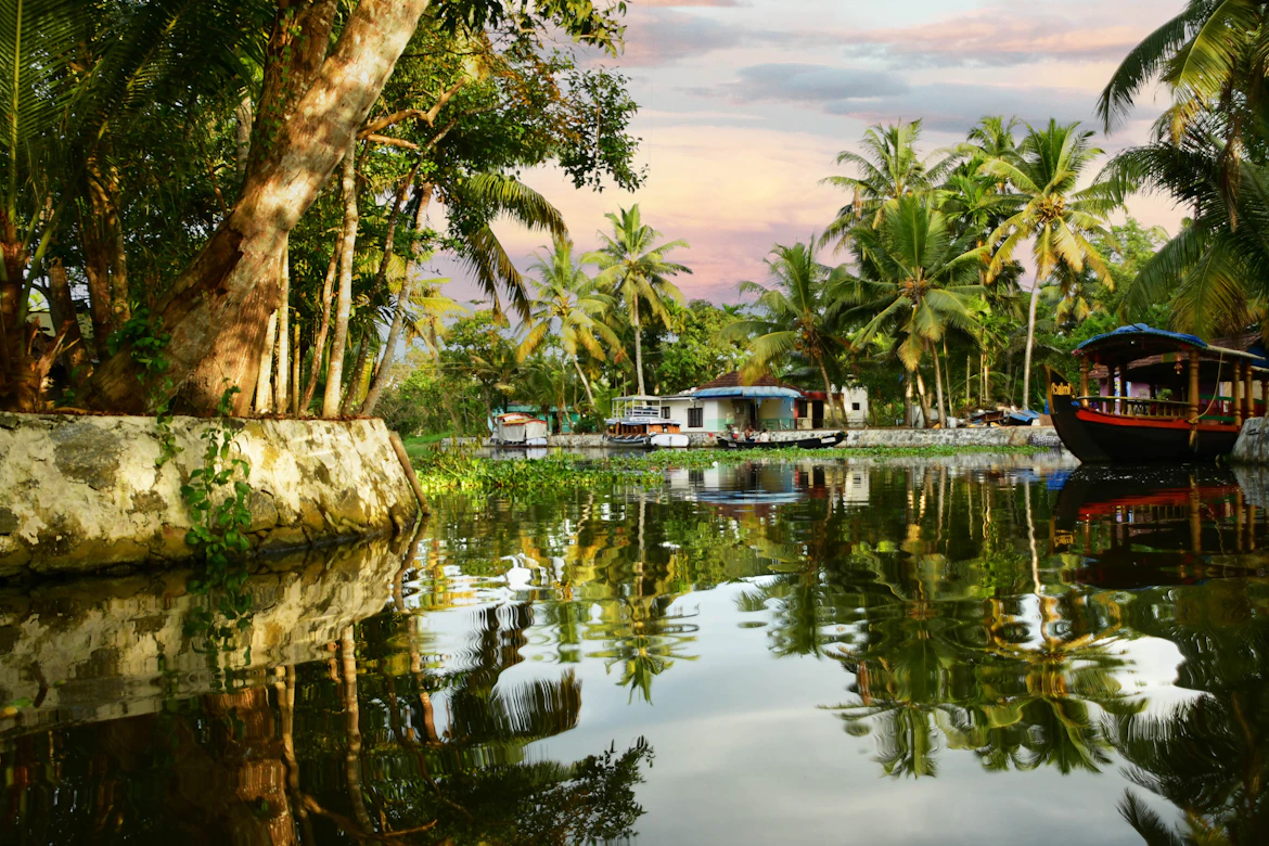 Kerala houseboat gliding through Alleppey backwaters at sunset — Kerala family tour package from India