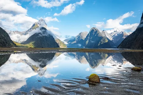 New Zealand Family Grand Circuit | Safari Sutra Holidays Milford Sound fjord with mirror-still water and Mitre Peak — New Zealand family tour package from India