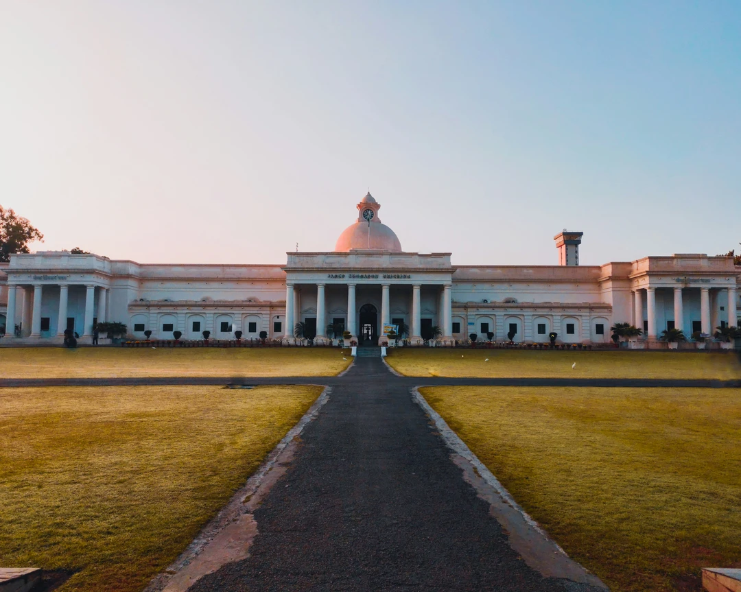White domed museum building with broad lawn in front at golden hour