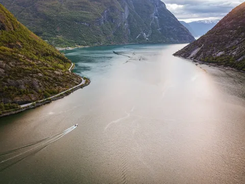 Rails, Fjords & the Coastal Voyage North: Norway at an Easy Pace | Safari Sutra Holidays Boat on the narrow Nærøyfjord between steep mountains on a Norway senior citizens tour