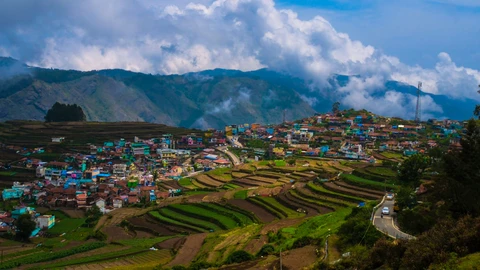 A panoramic view of the colorful Poombarai village and its surrounding terraced farms in the hills of Kodaikanal