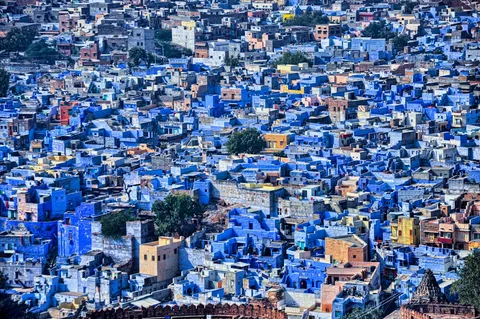 Rajasthan Through the Lens: Shekhawati, Pushkar, Jodhpur & Jaisalmer | Safari Sutra Holidays Aerial view of Jodhpur blue city rooftops at dawn — Rajasthan photography tour from India