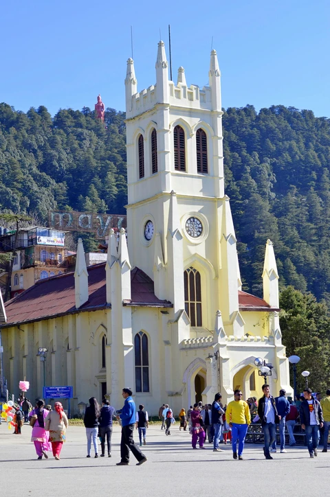 Christ Church on The Ridge, a Shimla Landmark The historic Christ Church in Shimla, with tourists on The Ridge and the Jakhu Temple statue on the hill behind.