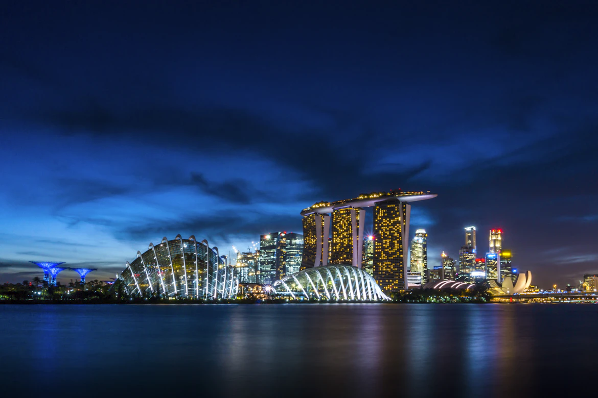 ingapore Family Adventure: 4 Nights of Theme Parks, Night Safari & Island Fun | Safari Sutra Holidays Singapore Marina Bay Sands skyline at night reflected in water — Singapore family tour package from India