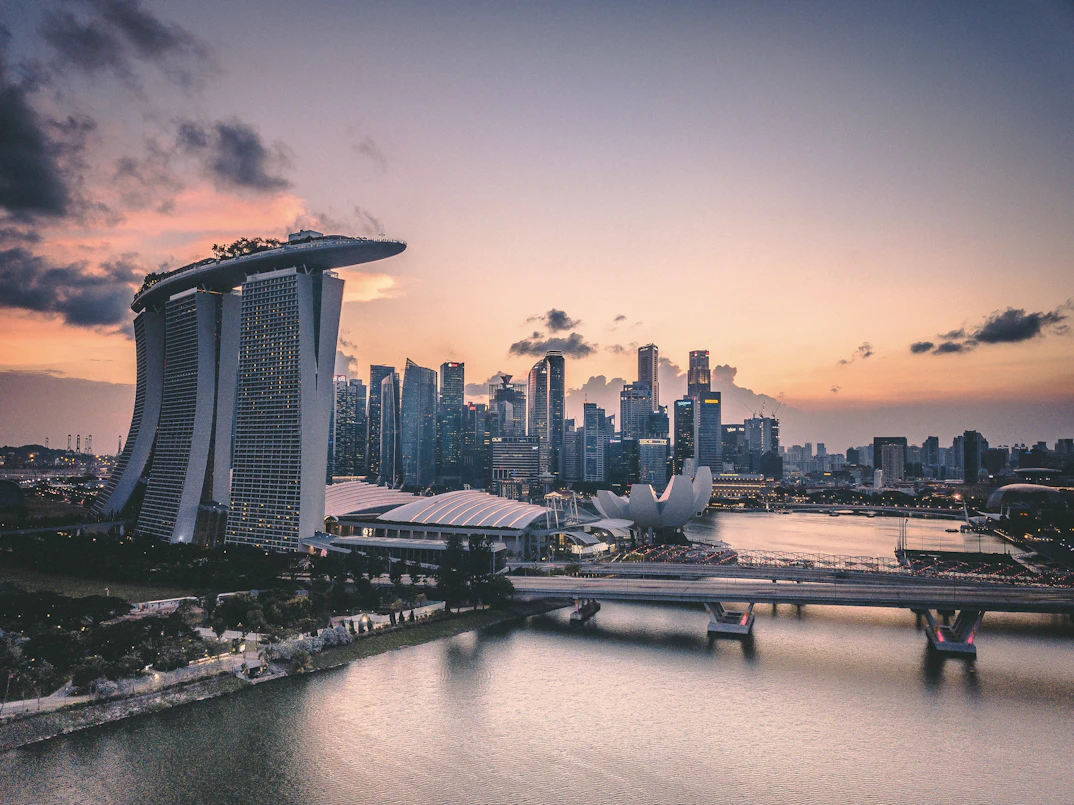 Singapore Honeymoon Glow: 5 Nights of Rooftop Dinners, Island Sunsets & City Lights | Safari Sutra Holidays Couple at Singapore Marina Bay Sands sunset with city skyline — Singapore honeymoon package from India