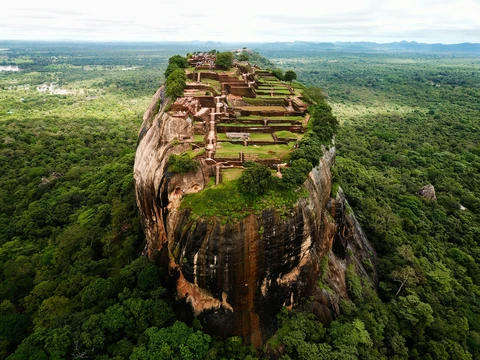 The Ancient Sigiriya Rock Fortress in Sri Lanka An aerial view of the Sigiriya rock fortress, showing the ancient palace ruins on top of the massive rock rising from the jungle